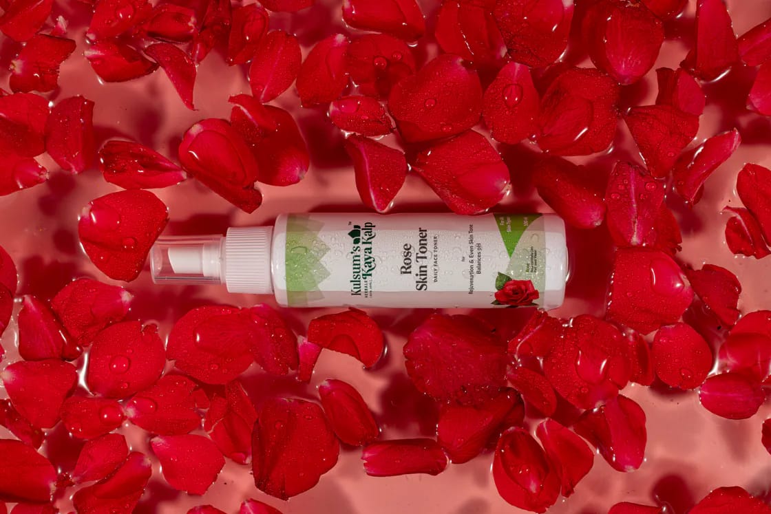 Serum bottle among red rose petals